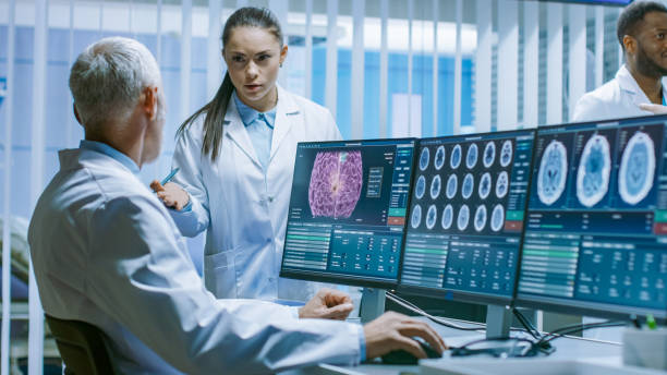istock Two Medical Scientists in the Brain Research Laboratory Discussing Progress on the Neurophysiology Project Fighting Tumors. Neuroscientists Use Personal Computer with MRI, CT Scans Show Brain Images. 1050311520