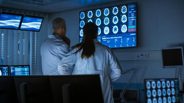istock Two Medical Scientists / Neurologists, Talking and Working on a Personal Computer in Modern Laboratory. Research Scientists Making New Discoveries in the fields of Neurophysiology, Science, Neuropharmacology. Understanding Human Brain. 1050311864