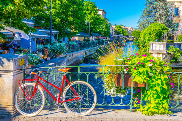 bicicleta a una barandilla en el centro histórico de l ' isle sur la sorgue en francia - lisle fotografías e imágenes de stock