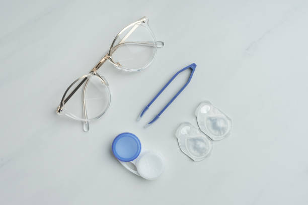 istock flat lay with eyeglasses, contact lenses containers and tweezers arranged on white surface 1050318970