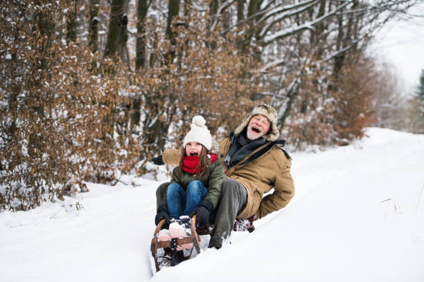 abuelo y niña trineo en un día de invierno. - deslizarse en trineo fotografías e imágenes de stock