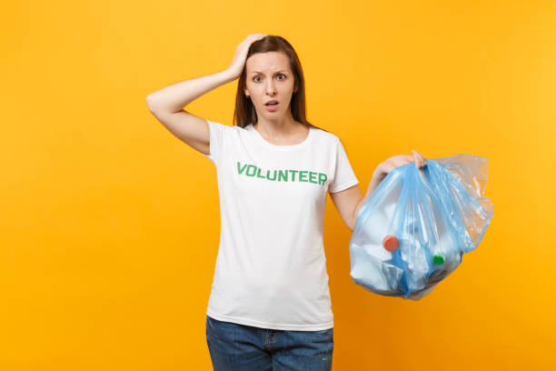 Woman in t-shirt volunteer, trash bag isolated on yellow background. Voluntary free assistance help, charity grace. Environmental pollution problem. Stop nature garbage environment protection concept mujer en la basura voluntarios, camiseta bolsa aislada sobre fondo amarillo. ayuda voluntaria asistencia gratuita, gracia de caridad. problema de contaminación ambiental. dejar el concepto de la protección del medio ambiente de naturaleza basura.