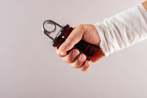 istock hurt hand doing rehabilitation exercises by squeezing an A shape hand trainer 1050340118