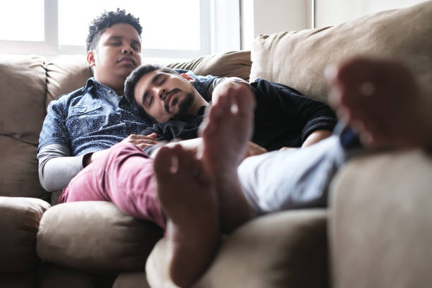 istock Young Gay Men Sleeping And Relaxing On Sofa At Home 1050343148