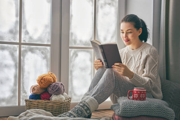 istock woman sitting by the window 1050346542