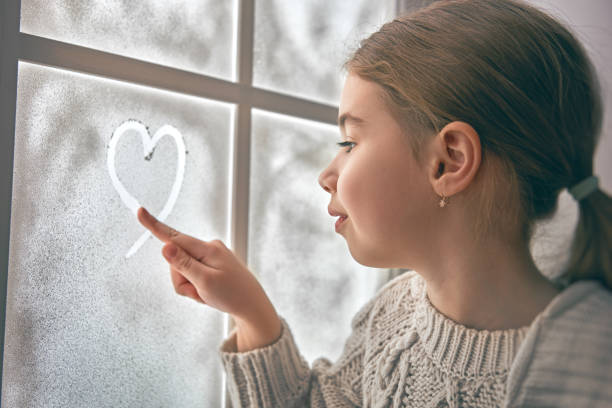 istock girl sitting by the window 1050346560