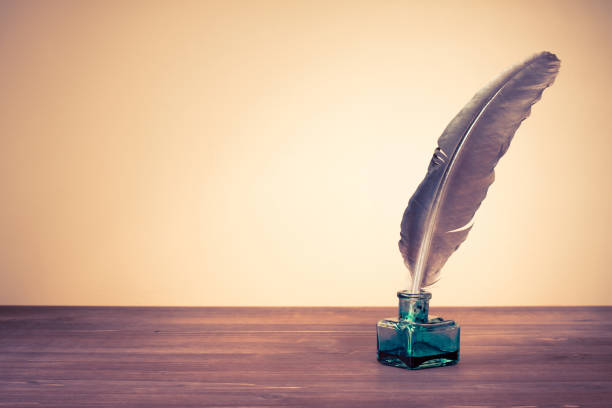 Vintage old quill pen, inkwell on wooden table. Retro style filtered photo stock photo