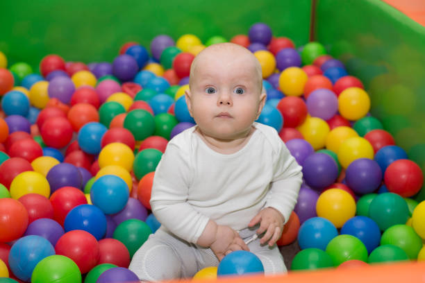 little baby boy sits in the pool with balls - ball pool imagens e fotografias de stock