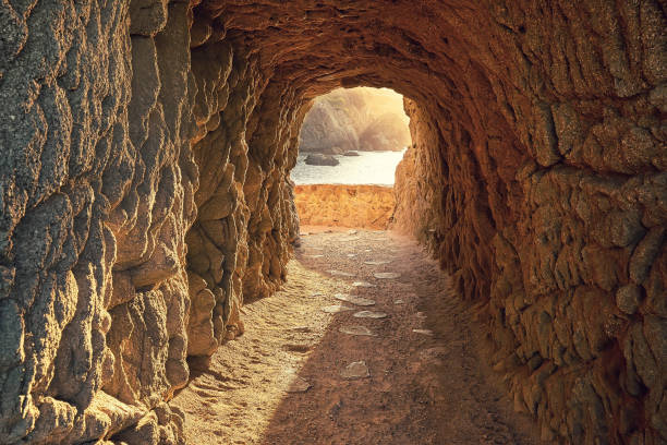 Path through a cave to sunrise over the sea