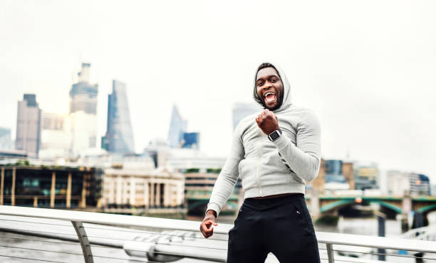istock Black man runner with smart watch on the bridge in a city, resting. 1050363836