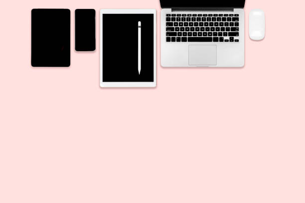istock Flat lay photo of office table with laptop computer, digital tablet, mobile phone and accessories. on modern pink tone background. Desktop office mockup concept. 1050383594