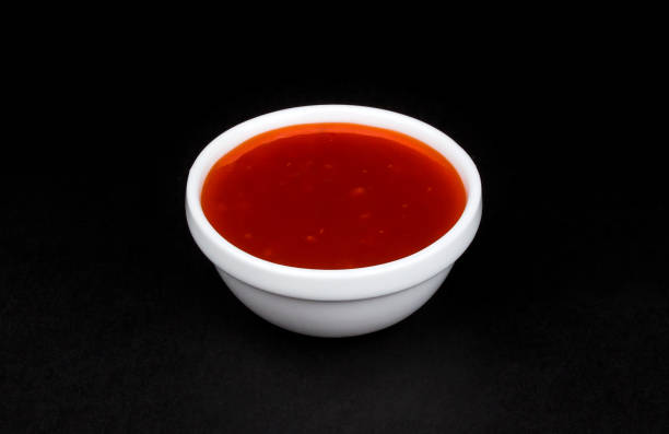 검은 배경에 고립 된 그릇에 뜨거운 고추 소스 - sweet chili 뉴스 사진 이미지