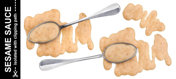 istock Splash of sesame sauce with spoon isolated on white background. Top view 1050407554