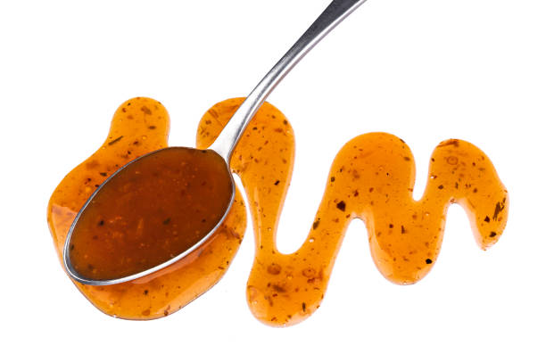 istock Sweet and sour sauce with spoon isolated on white background 1050410180