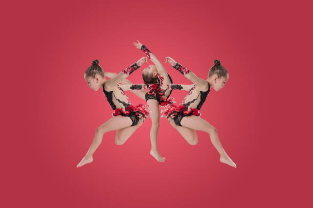 The little ballerina dancer jumping in studio on colored background