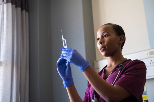 istock Female healthcare worker preparing a sharp for injection 1050413860