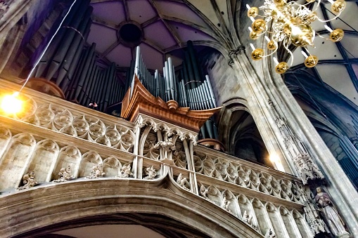 organ in the Catholic Church, pipes of the organ under the ceiling of the Catholic church, stone carvings and stucco moldings