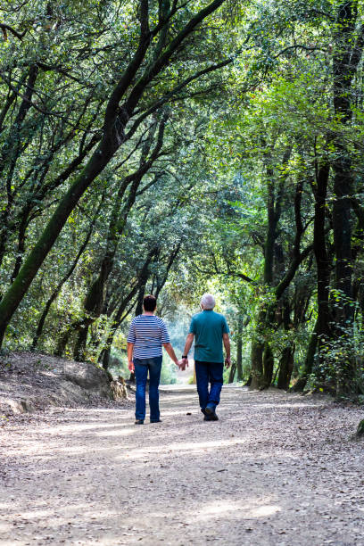 istock Retired couple walking together on the path of a forest 1050423612