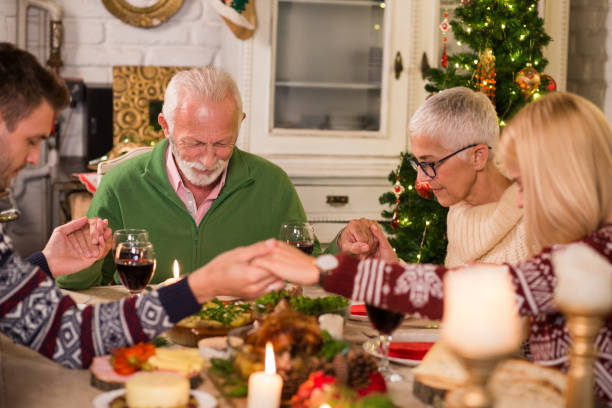 istock Family praying at Christmas table 1050428820