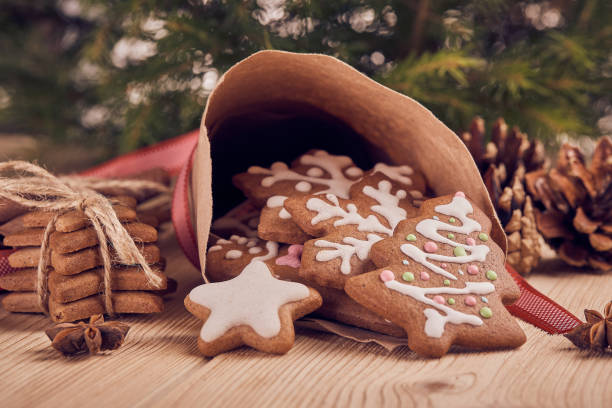 Christmas gingerbread cookies. Christmas gingerbreads. Christmas decorations. Handmade cookies in paper cone  lying on the wooden table.  Christmas and New Year treats. Christmas Tree Cookie stock pictures, royalty-free photos & images