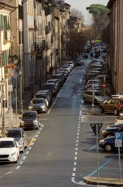 Long row of parked car in a street of Lucca (Tuscany, Italy) as seen from above the ancient walls surrounding the town