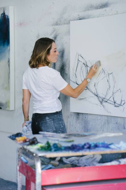 istock Woman painting canvas in art studio 1050437458