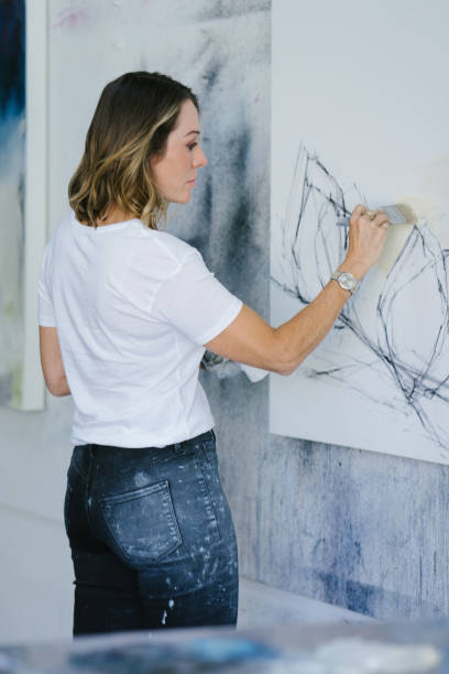 istock Woman painting canvas in art studio 1050437478