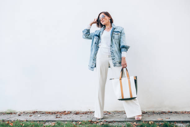 mulher posando com roupa elegante com saco de jaqueta e compras de jeans tamanho grande - young women sensuality sex symbol loneliness - fotografias e filmes do acervo