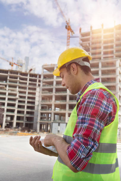 istock Young Engineer portrait with construction site and crane background. 1050440074