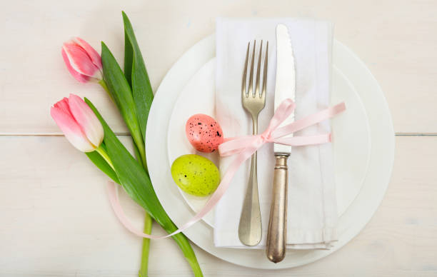 easter table setting with pink tulips on white wooden background. top view - silverware fork place setting napkin imagens e fotografias de stock