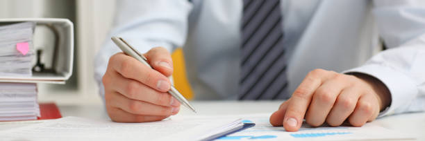 istock Male hand holding silver pen ready to 1050482394