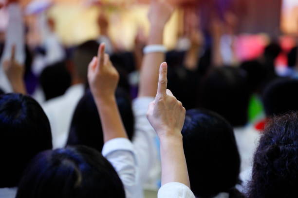 gente reacciona a la pregunta levantando su dedo índice juntos como equipo para la unidad y la unanimidad y la colaboración - arms raised pointing inspiration ideas fotografías e imágenes de stock