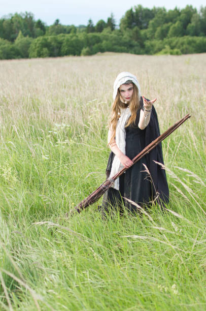 istock witch with a broom on a walk in a wild field 1050488068