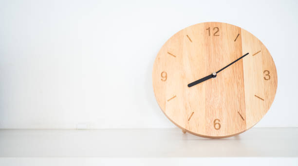 istock Wooden round wall clock on white shelf 1050497896
