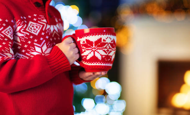 enfants à l’arbre de noël. enfants boivent du chocolat chaud. - 16621 photos et images de collection