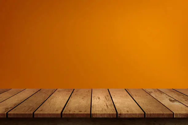 Photo of Halloween empty wooden tabletop on orange background. Use for product display montage.