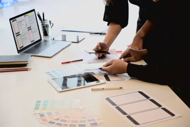 istock UI UX designer sketching layout design  application on mockup mobile phone. 1050511138