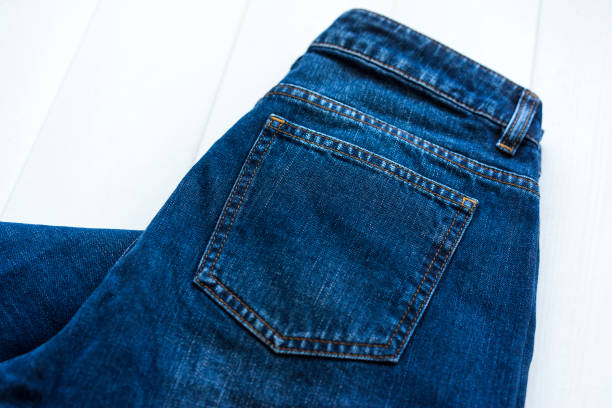 Blue jeans back pocket detail on white wooden background