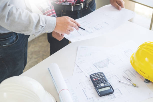 istock Midsection Of Architects Working On Blueprint 1050539930