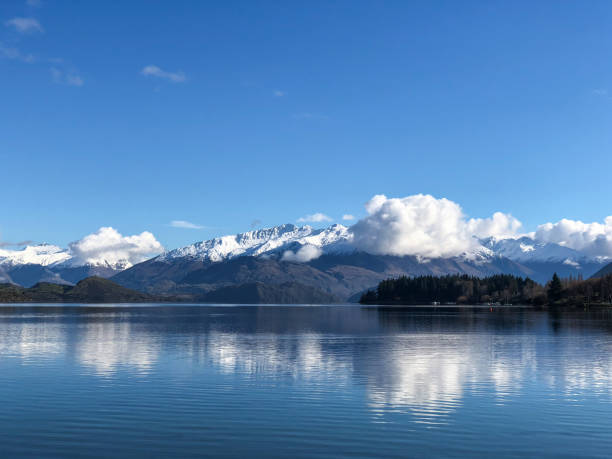 istock Roys bay at Wanaka with snow capped mountains and clouds in view 1050588764