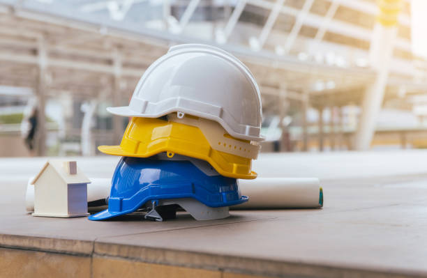 istock Hard hats safety helmet with home model,blueprint,Construction and Engineer 1050591574