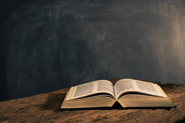 bible on a old oak wooden table. beautiful dark background.religion concept - god spirituality religion metal imagens e fotografias de stock