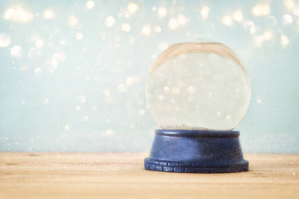 istock Empty Snow Globe over wooden table with glitter overlay. Magical Christmas concept. Copy space. 1050594414