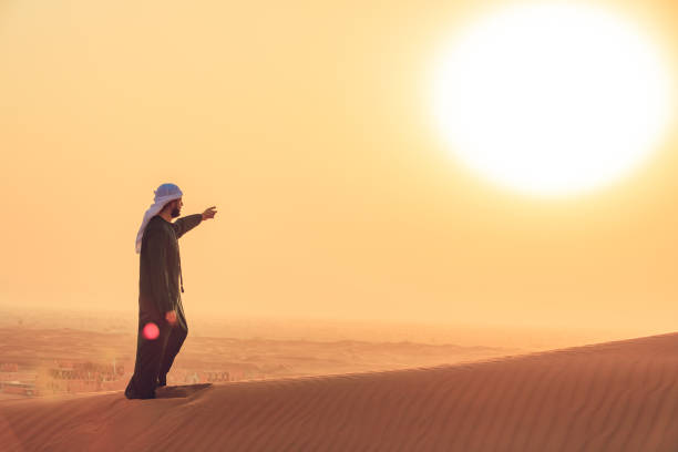 The Way Forward, Sunrise, Middle East, Desert, Arab Man - Emirati Man standing over a sand dune overlooking remote city and sunrise