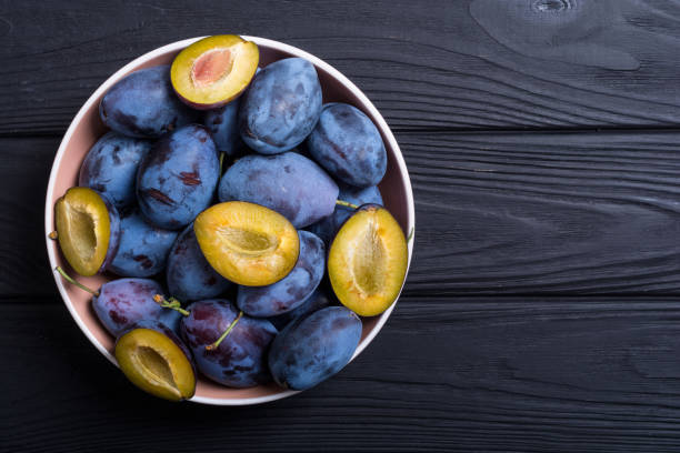 istock Fresh plums in bowl on wooden table 1050646614
