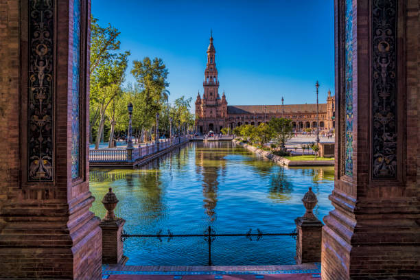 Old Historical Buildings In The Plaza De Espana In Seville Spain Seville, Spain - April 4, 2017: Looking Through Architectural Pillars At The View Of The Pond And Old Buildings Within The Plaza De Espana sevilla province stock pictures, royalty-free photos & images