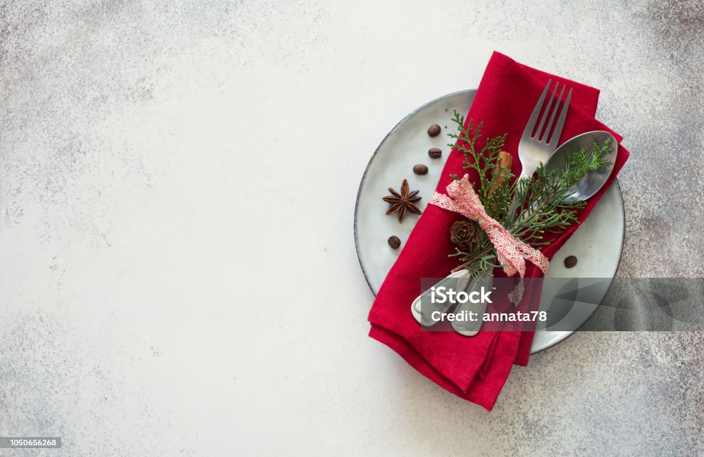 Chrismas table place setting. Tableware with evergreen twigs, cone and spice Chrismas table place setting. Tableware, evergreen twigs, cone and spice. New Year food concept Anise Stock Photo