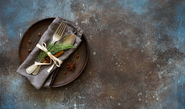 istock Chrismas table place setting. Tableware with evergreen twigs, cone and spice 1050659258