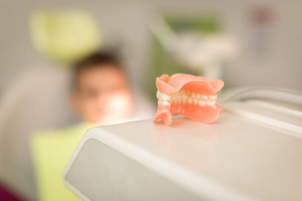 Cropped view with selective focus on dental tools with empty dental chair visible in the background.