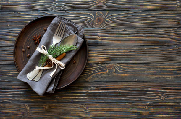 Christmas table place setting. Tableware with evergreen twigs, cone and spice